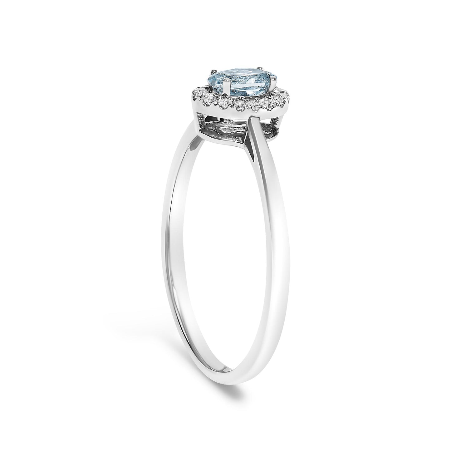 White metal ring with an oval blue gemstone in a prong setting surrounded by round white gemstones in a micro-pave setting, shown in a side angle.