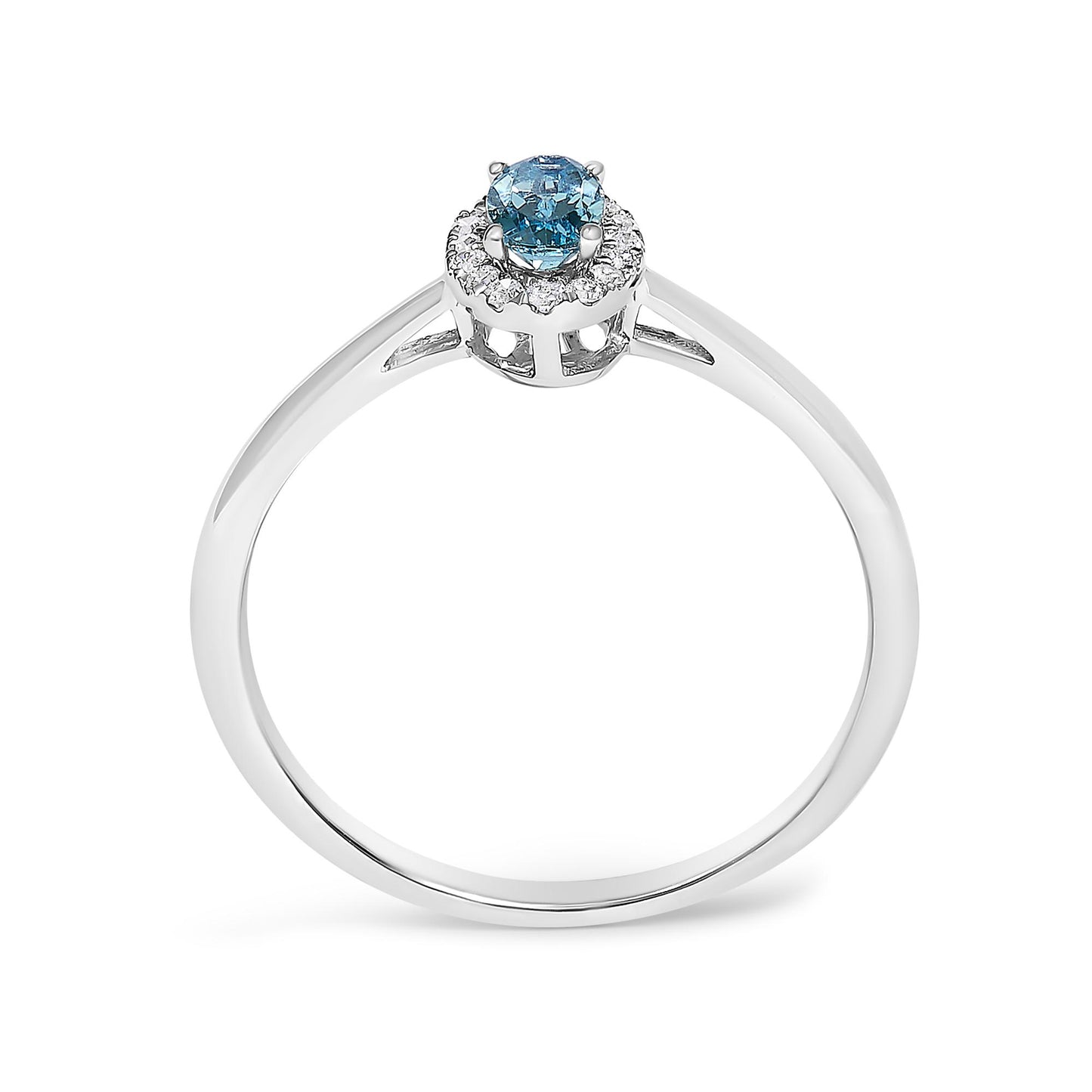 White metal ring with a round blue gemstone in the center, surrounded by small white gemstones in a halo design, shown from a front angled view on a white background.