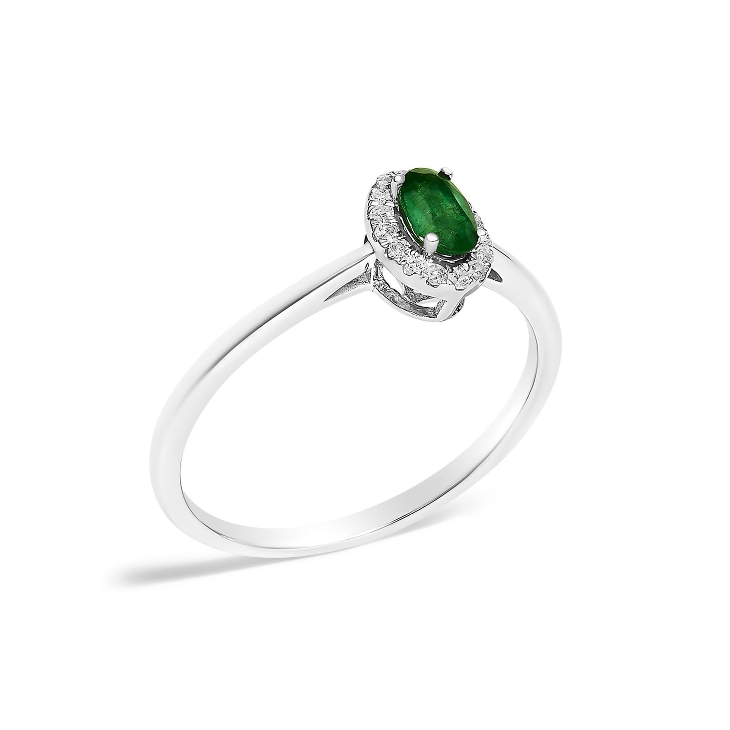 White metal ring with an oval green gemstone in prong setting surrounded by small round white gemstones in micro-pave setting, shown at an angled close-up.