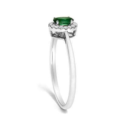 Side view of a white ring featuring an oval green gemstone in a prong setting, surrounded by a circle of small white round gemstones in a micro-pave setting.