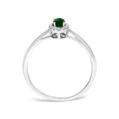 Front angle view of a white ring featuring a central oval green gemstone in prong setting, surrounded by a halo of small round white gemstones in micro-pave setting, shown on a white background.