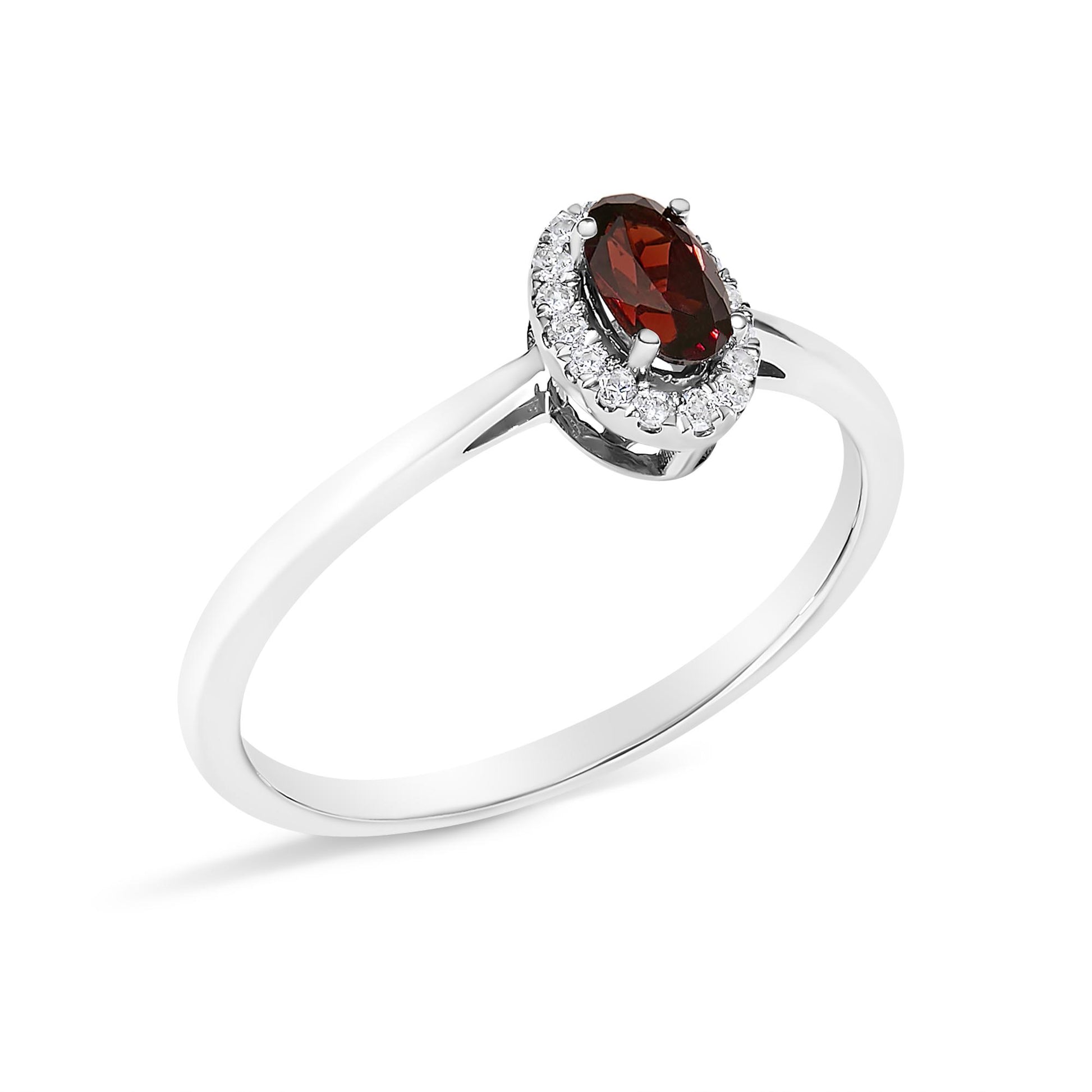 White metal ring with an oval red gemstone in a prong setting, surrounded by a micro-pave setting of small round white gemstones, shown in a close-up angled view.