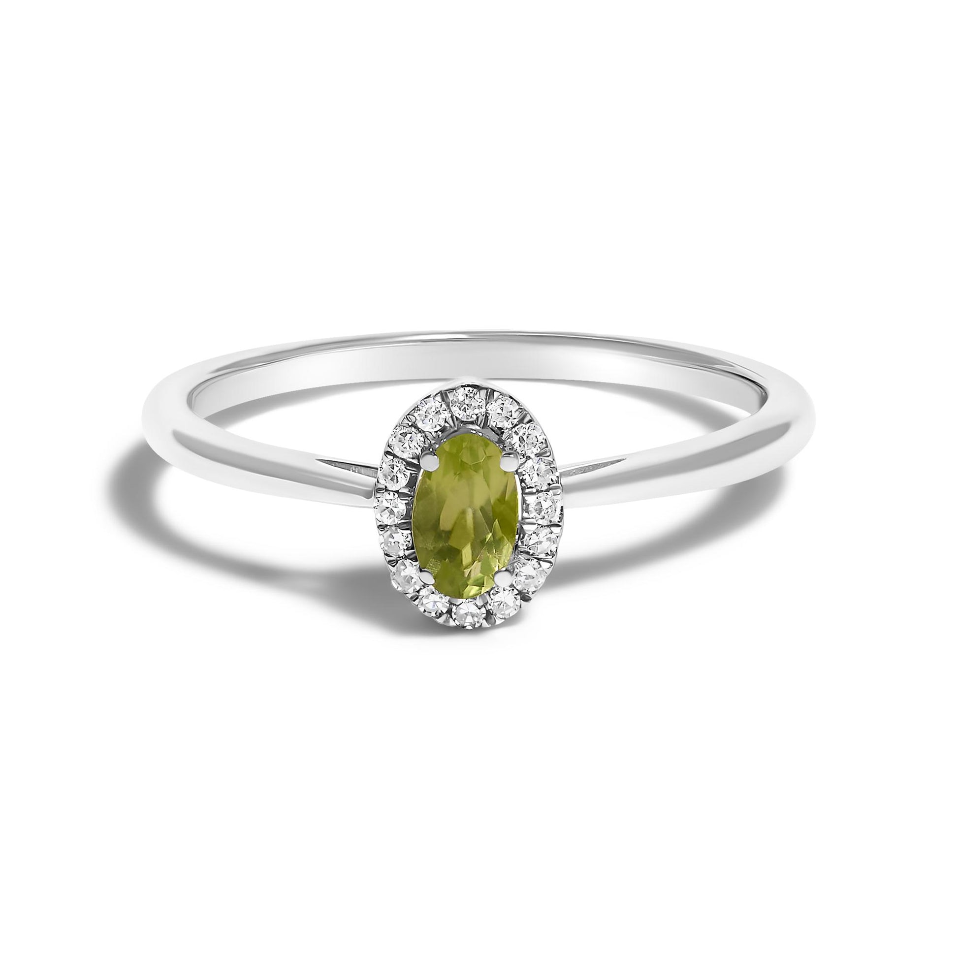 White metal ring with an oval green gemstone in a prong setting, surrounded by small round white gemstones in a micro-pave setting, shown in a front-facing close-up angle.