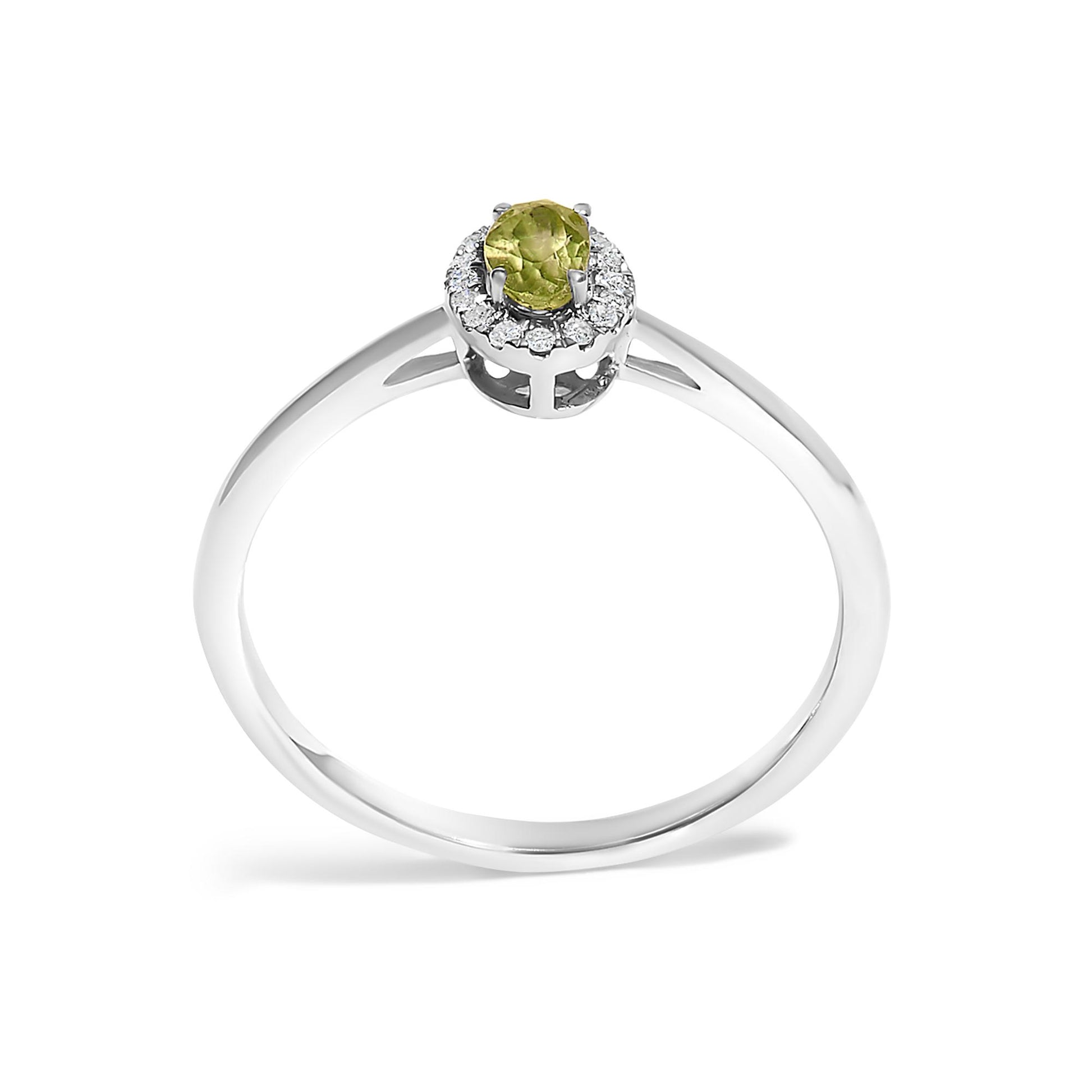 White metal ring with an oval green gemstone in a prong setting, surrounded by small white gemstones in a micro-pave setting, shown from a front angle on a white background.