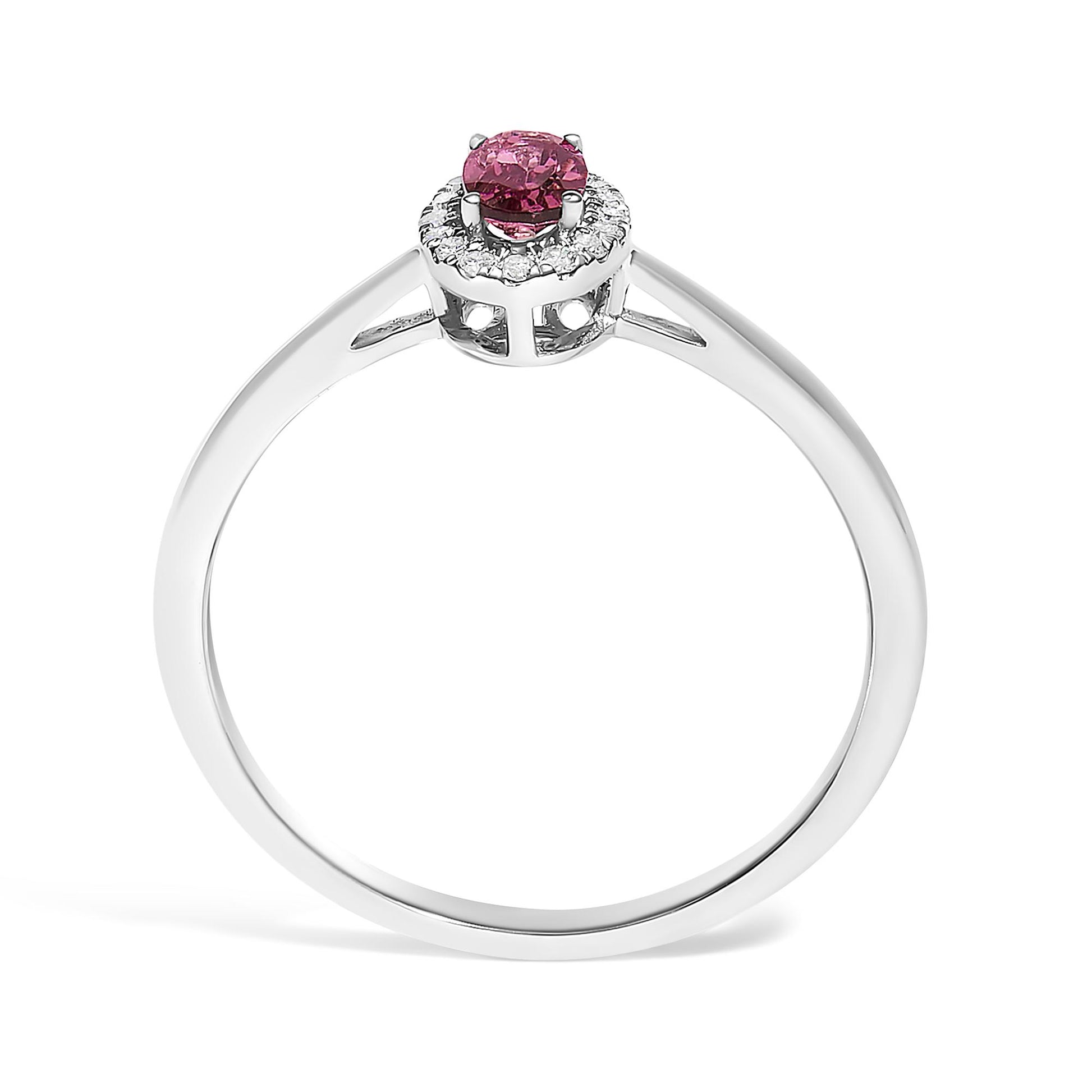 White metal ring with a round cluster of small white gemstones surrounding a prong-set oval pink gemstone, shown from a front angle on a white background.