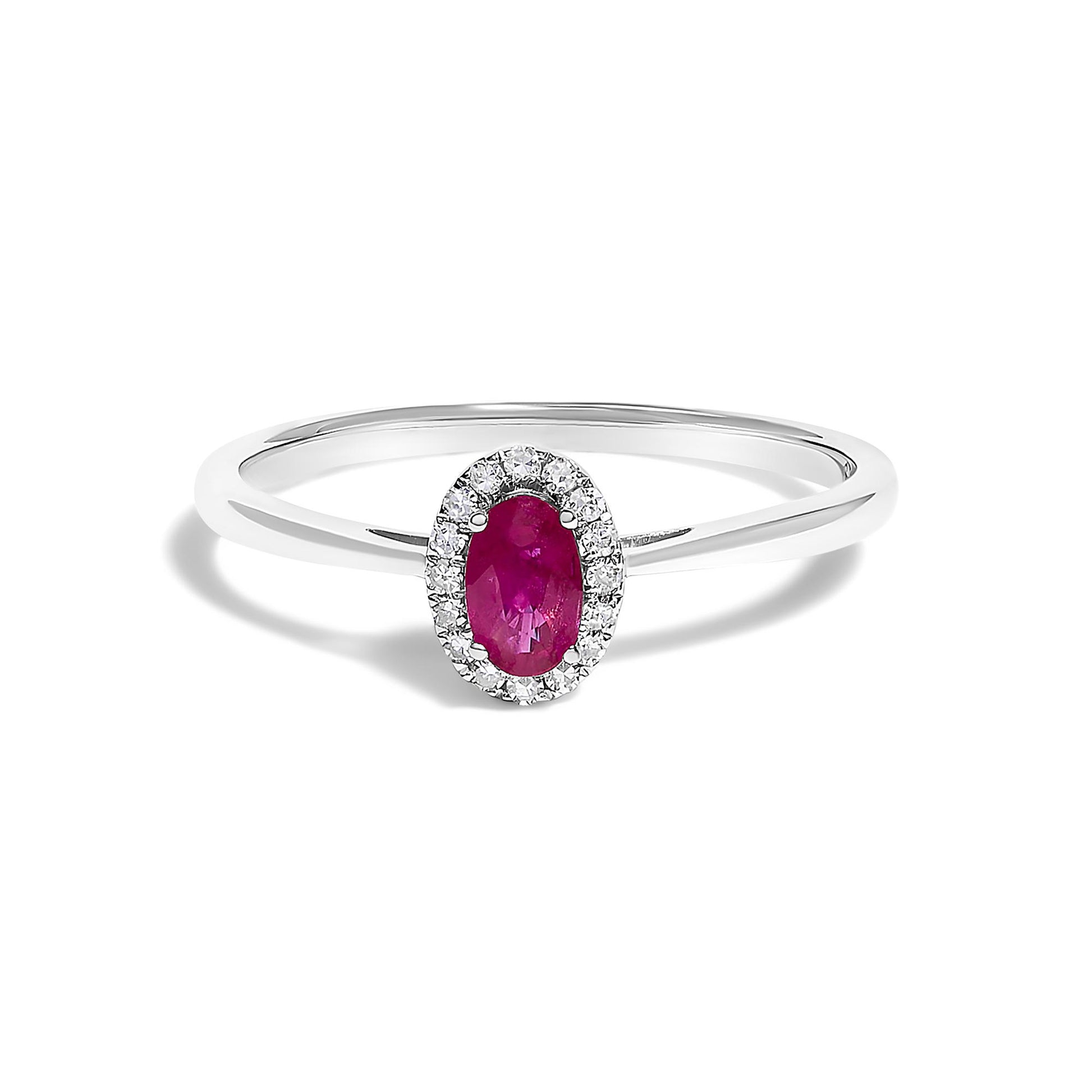 White metal ring with an oval red gemstone in a prong setting at the center, surrounded by a halo of small round white gemstones in a micro-pave setting, shown in a front close-up view on a white background.
