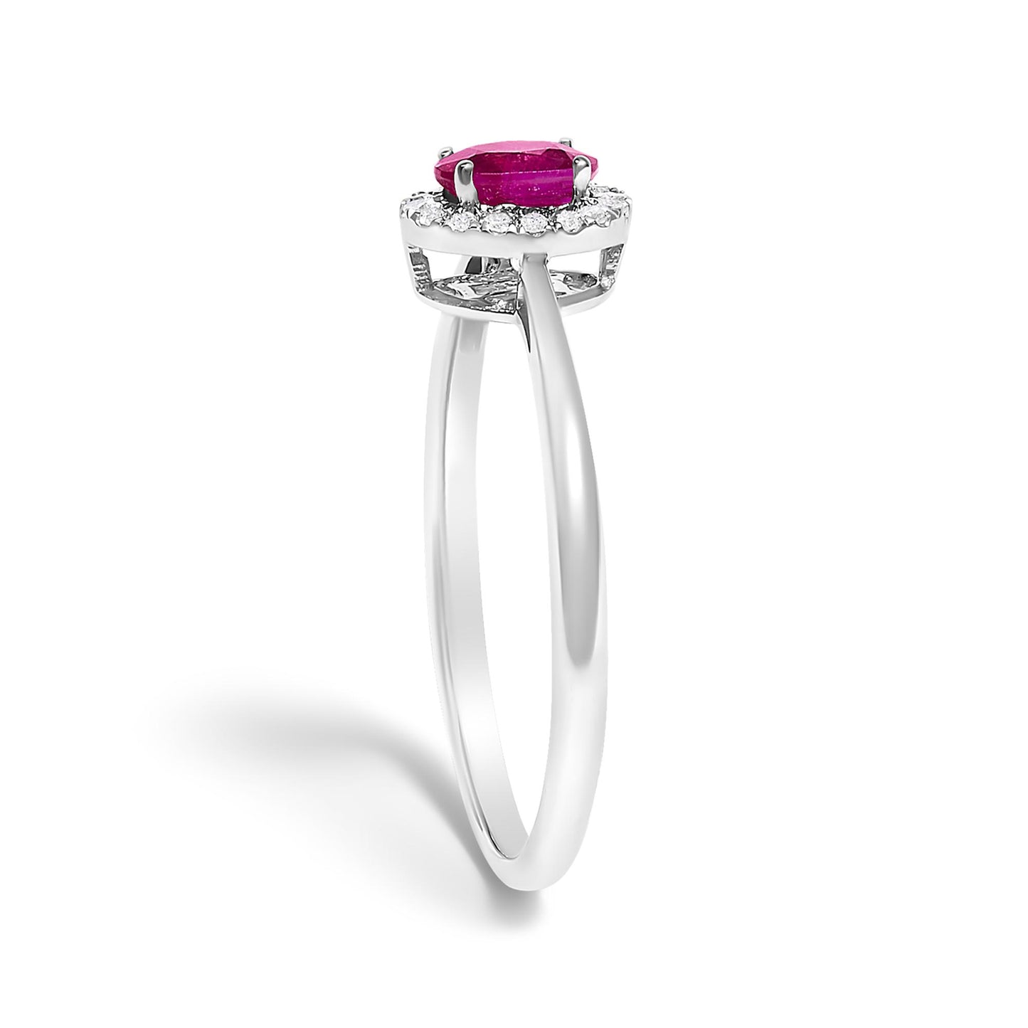 White metal ring shown from the side angle, featuring a single red oval-shaped gemstone in prong setting surrounded by a halo of small white round gemstones in micro-pave setting.