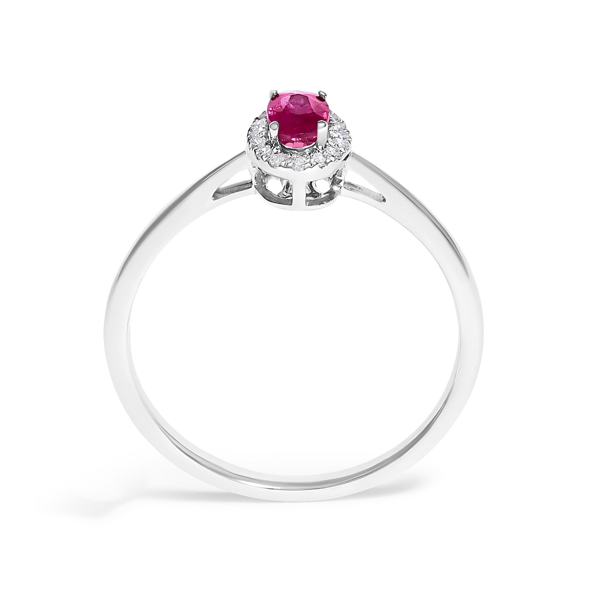 Front angle view of a white metal ring featuring a red oval gemstone in a prong setting, surrounded by small white round gemstones in a micro-pave setting.