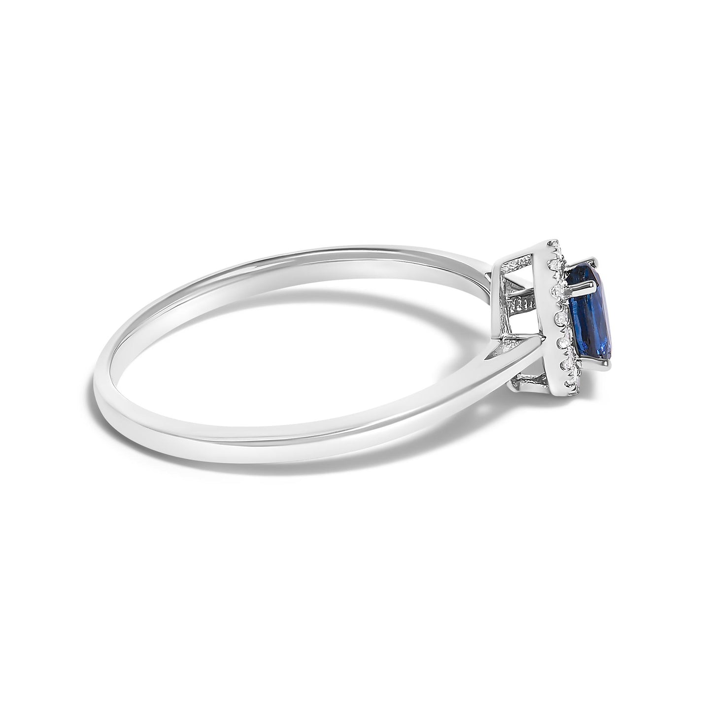 Side angle close-up of a white metal ring with a blue oval gemstone set in prongs, surrounded by small white round gemstones in a micro-pave setting.