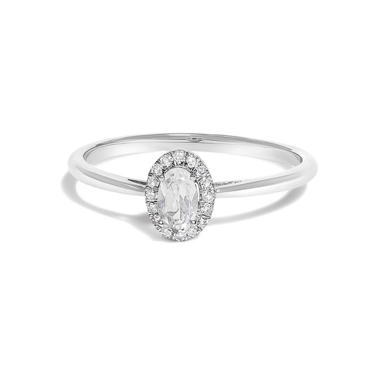White metal ring with an oval-shaped white gemstone in a prong setting, surrounded by small round white gemstones in a micro-pave setting, shown in a front-facing angle.