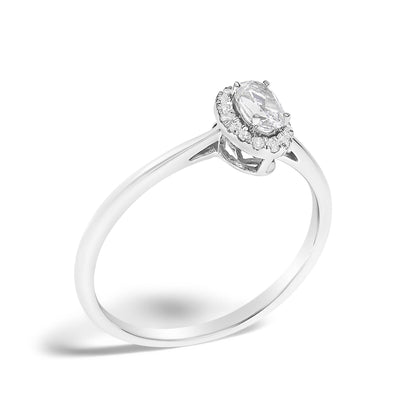 White metal ring with an oval white gemstone set in prongs, surrounded by round white gemstones in a micro-pave setting, shown from an angled top view on a white background.