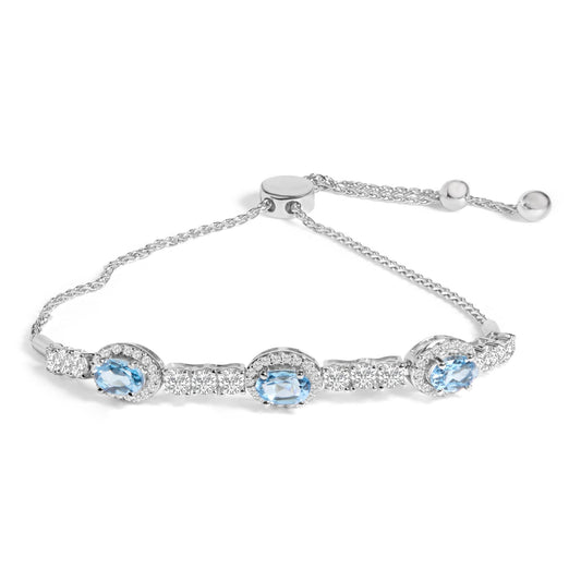 White metal bracelet with three oval blue gemstones surrounded by small white gemstones and additional white gemstones along the chain, shown in a close-up angled shot on a white background.