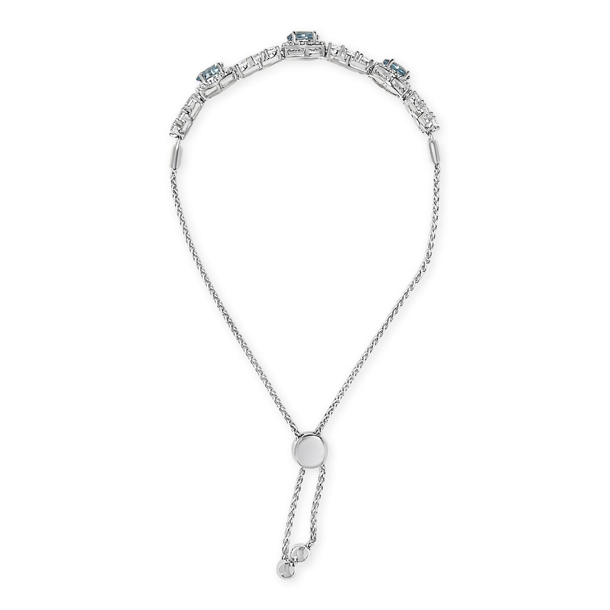 White metal bracelet shown from a top-down angle featuring a chain with an adjustable slider and a section with blue oval gemstones and multiple small white round gemstones in prong settings.
