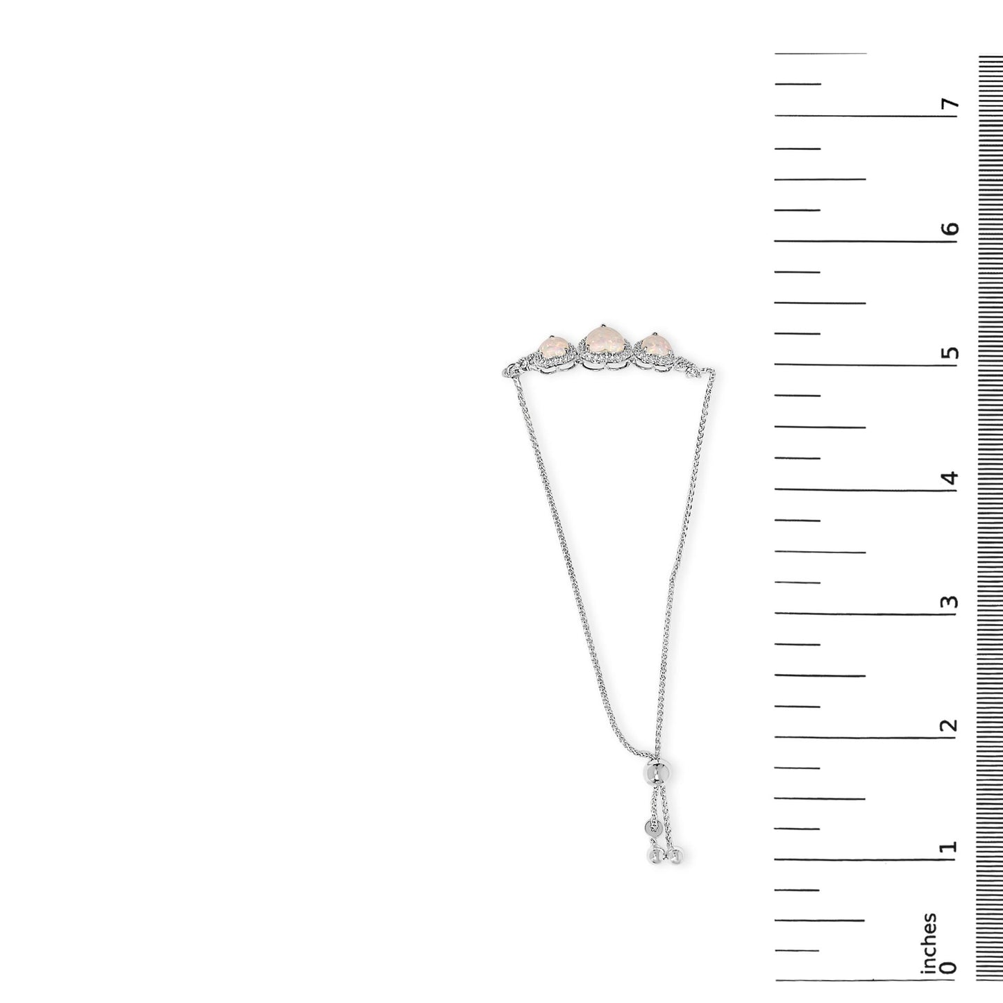 White metal bracelet with three heart-shaped white opal gemstones and numerous round white sapphire gemstones in prong settings, shown on a scale from a top-down angle.