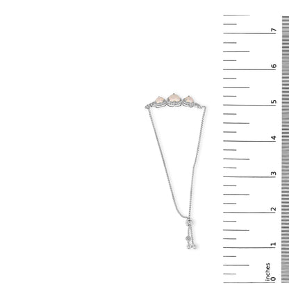 White metal bracelet with three heart-shaped white opal gemstones and numerous round white sapphire gemstones in prong settings, shown on a scale from a top-down angle.