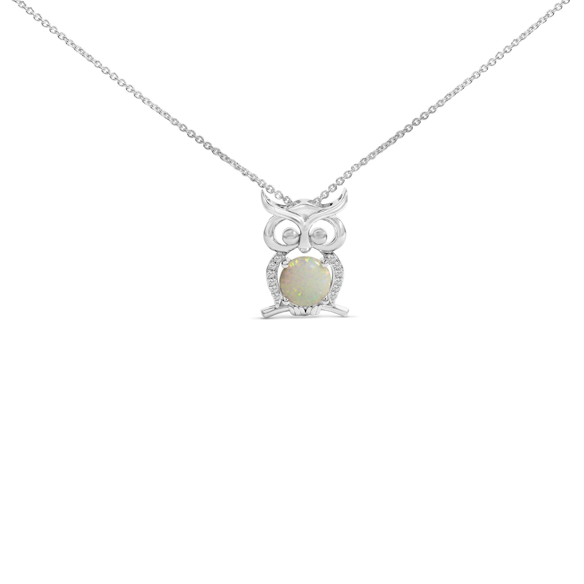 Front view of a white metal owl-shaped necklace pendant featuring a round white opal gemstone at the center held by four prongs, surrounded by small round white gemstones in prong settings, shown on a white background.