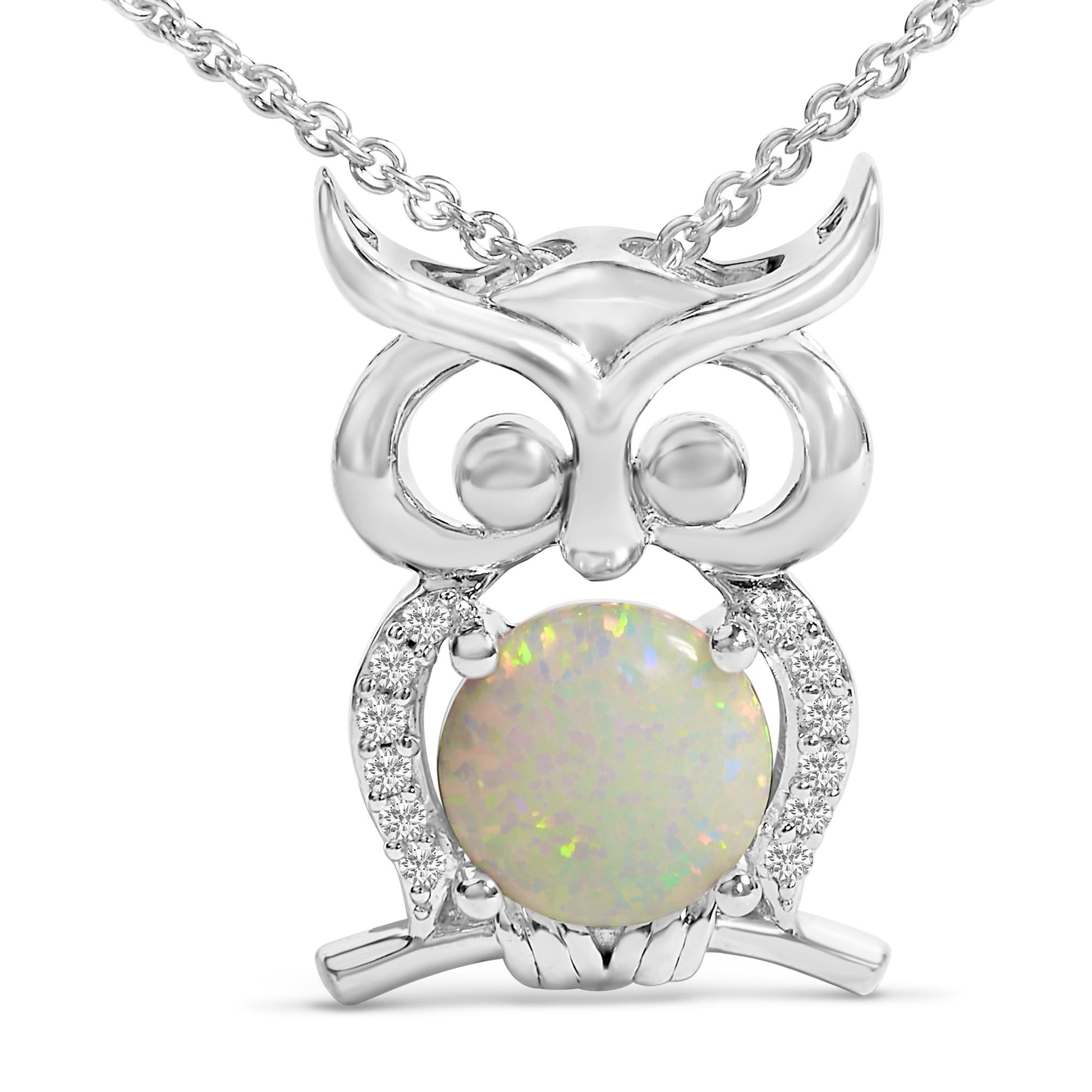 Close-up front angle of a white metal owl-shaped necklace pendant featuring a round white opal gemstone in the center and surrounded by multiple small white gemstones along the body, shown on a white background.