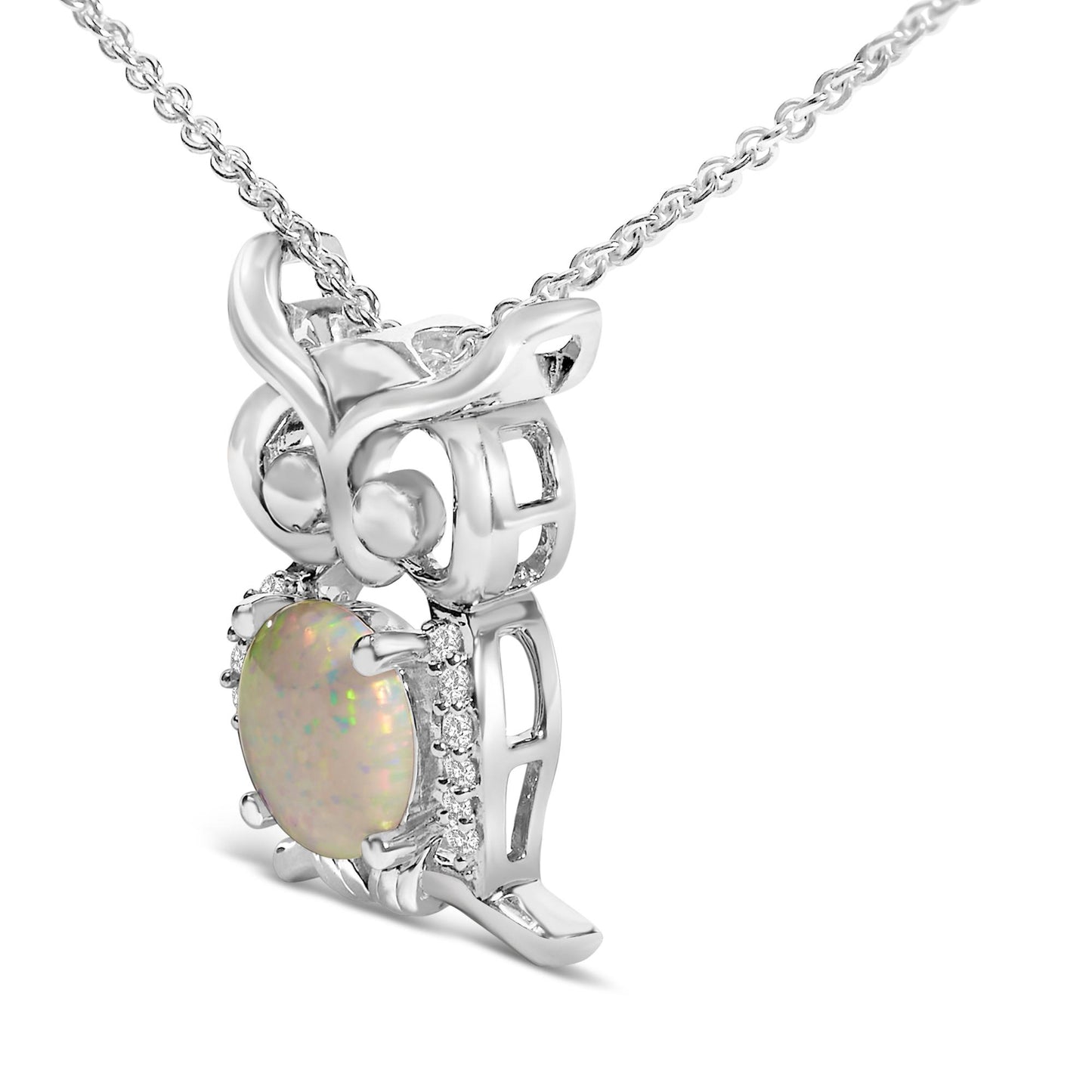 Close-up angled view of a white metal owl-shaped necklace pendant featuring a round white opal gemstone in a 4-prong setting at the center and surrounded by round white gemstones in prong settings.