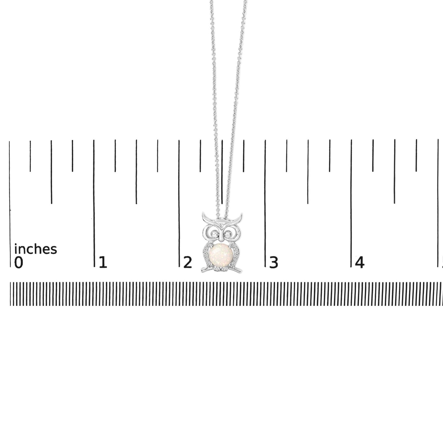 White metal owl-shaped necklace with a central round white opal gemstone and small round white sapphire gemstones surrounding it, shown on a scale with a front-facing angle.