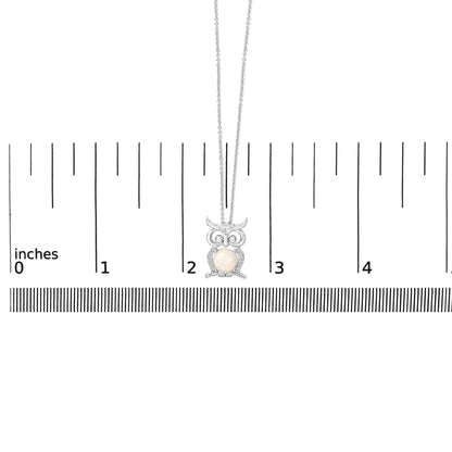White metal owl-shaped necklace with a central round white opal gemstone and small round white sapphire gemstones surrounding it, shown on a scale with a front-facing angle.