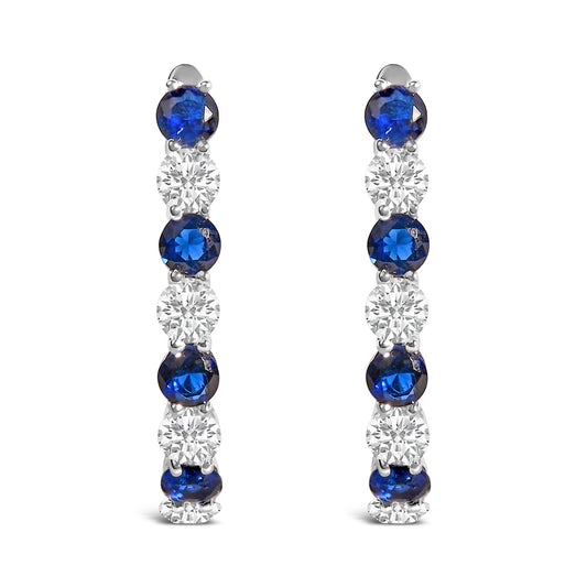 Pair of white metal earrings shown from the front, featuring a vertical row of alternating blue and white round gemstones in shared prong settings.