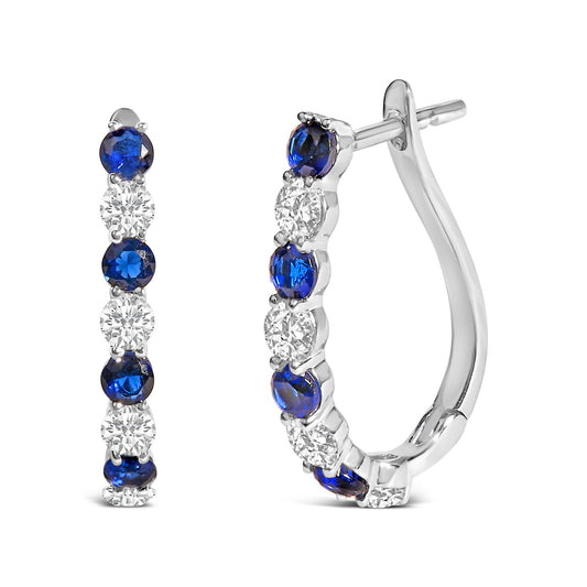 Pair of white metal hoop earrings with alternating round blue and white gemstones in shared prong settings, shown in a close-up front and side view on a white background.