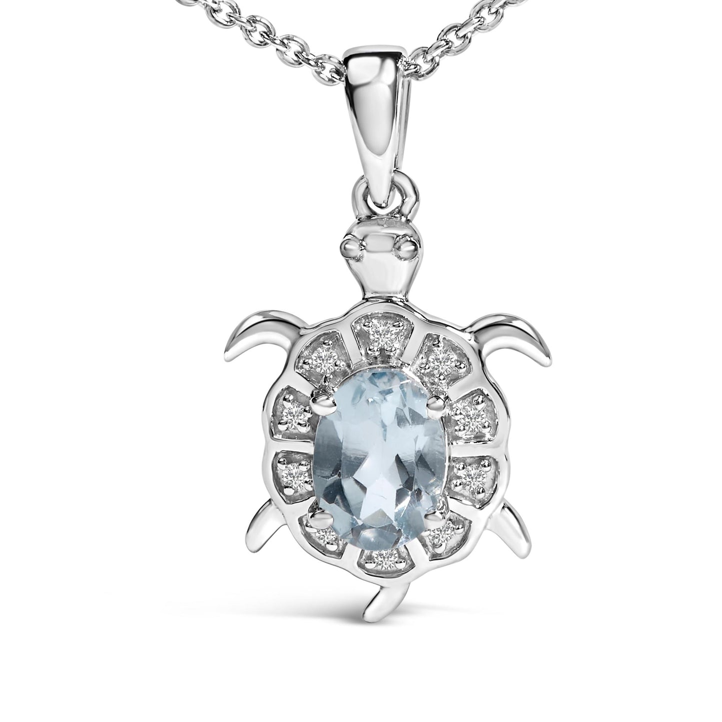 White metal necklace pendant in the shape of a turtle, featuring an oval blue gemstone in a four-prong setting at the center surrounded by smaller round white gemstones in prong settings, shown in a front close-up view.