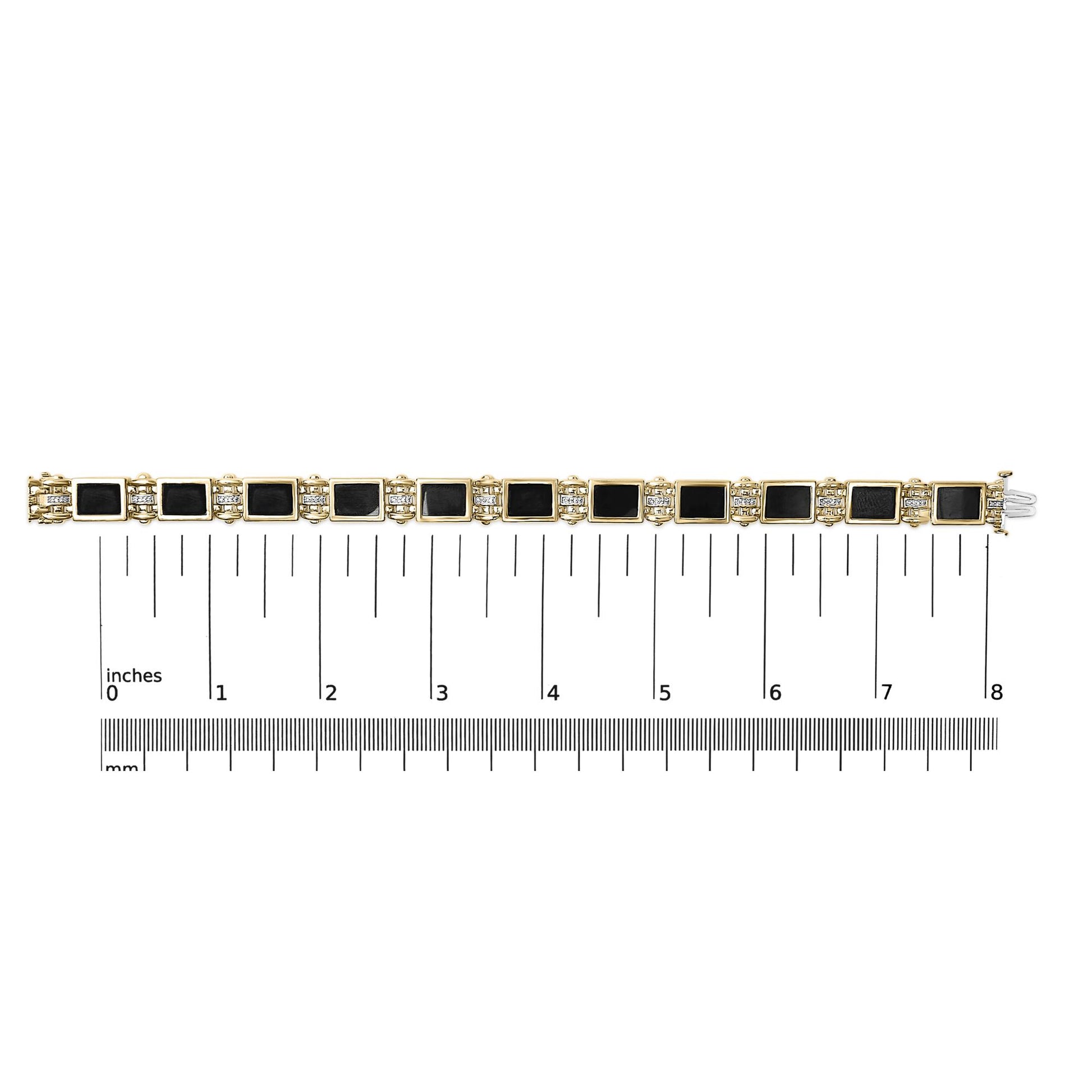 Yellow metal bracelet with square black gemstones and round white gemstones in between, shown flat on a measuring scale from above.