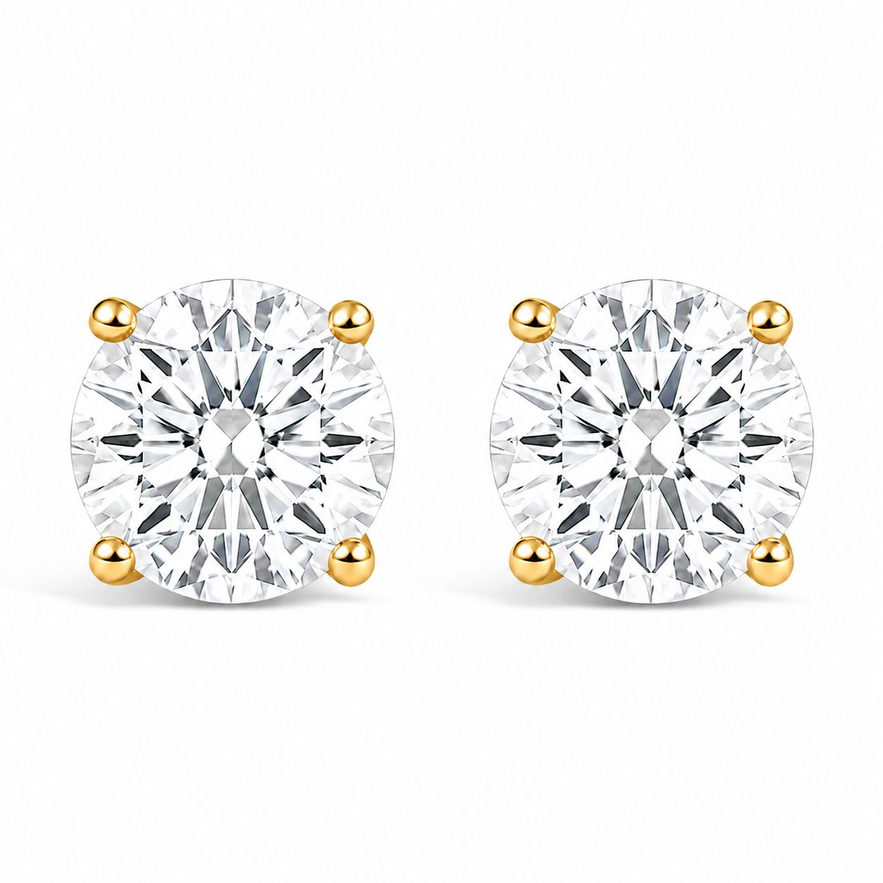 Pair of yellow metal stud earrings with round white gemstones in four-prong settings, shown from the front on a white background.