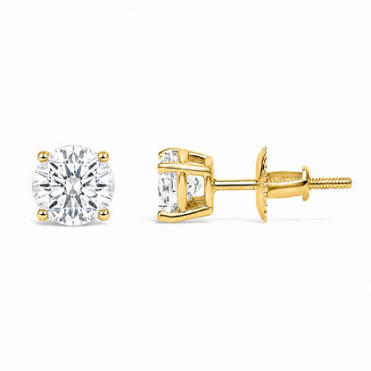 Pair of yellow metal stud earrings with round white gemstones in 4-prong settings, shown in a front and side angle on a white background.