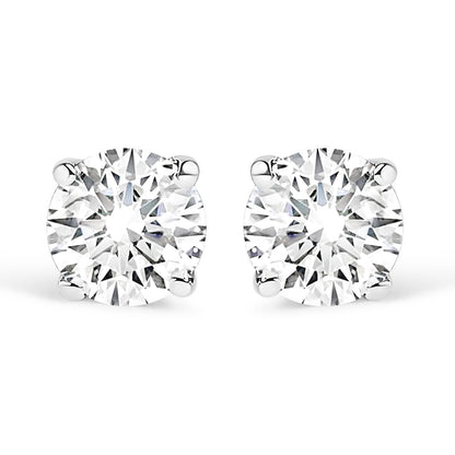 Front-facing close-up of a pair of white stud earrings each set with a round white gemstone in a four-prong setting.