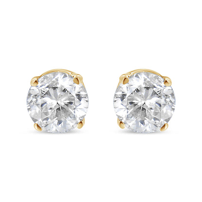 Pair of yellow metal stud earrings with round white gemstones in 4-prong settings, shown from a front angle.