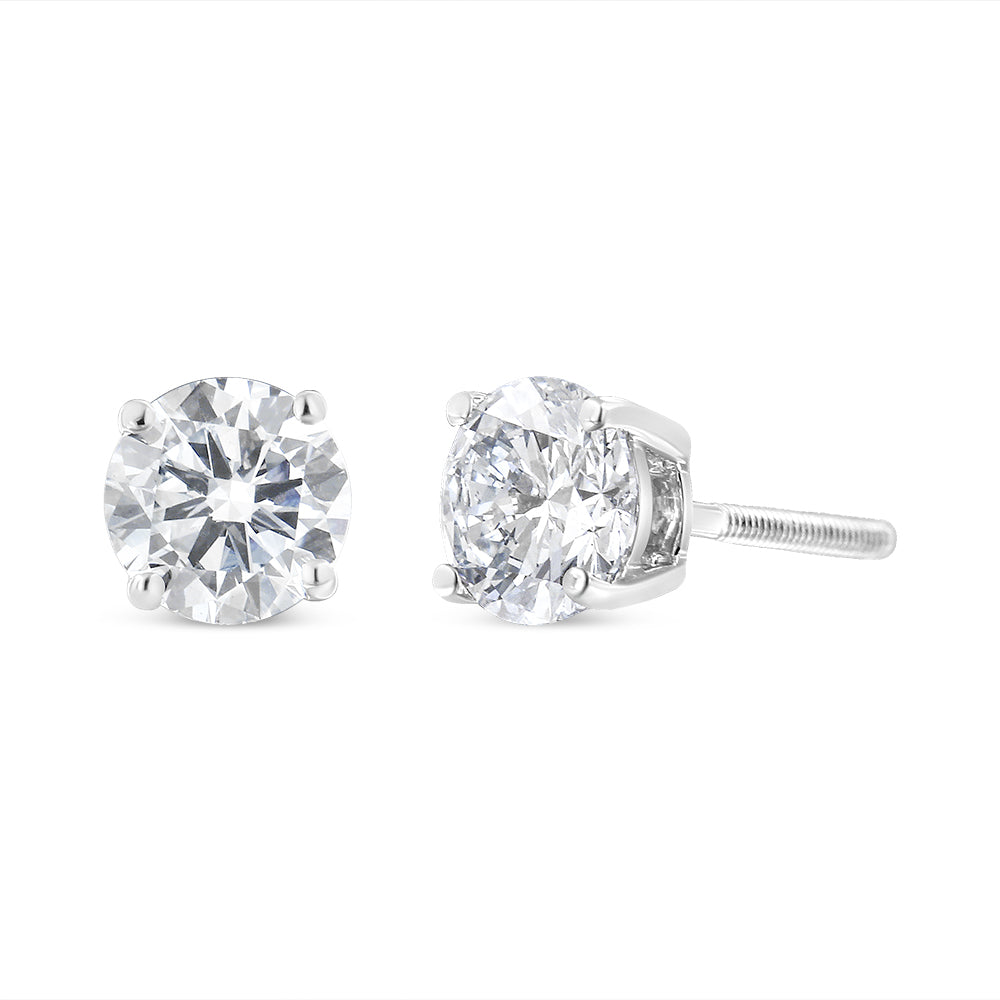 Pair of white metal stud earrings with round white gemstones in four-prong settings, shown from a front and side angle.
