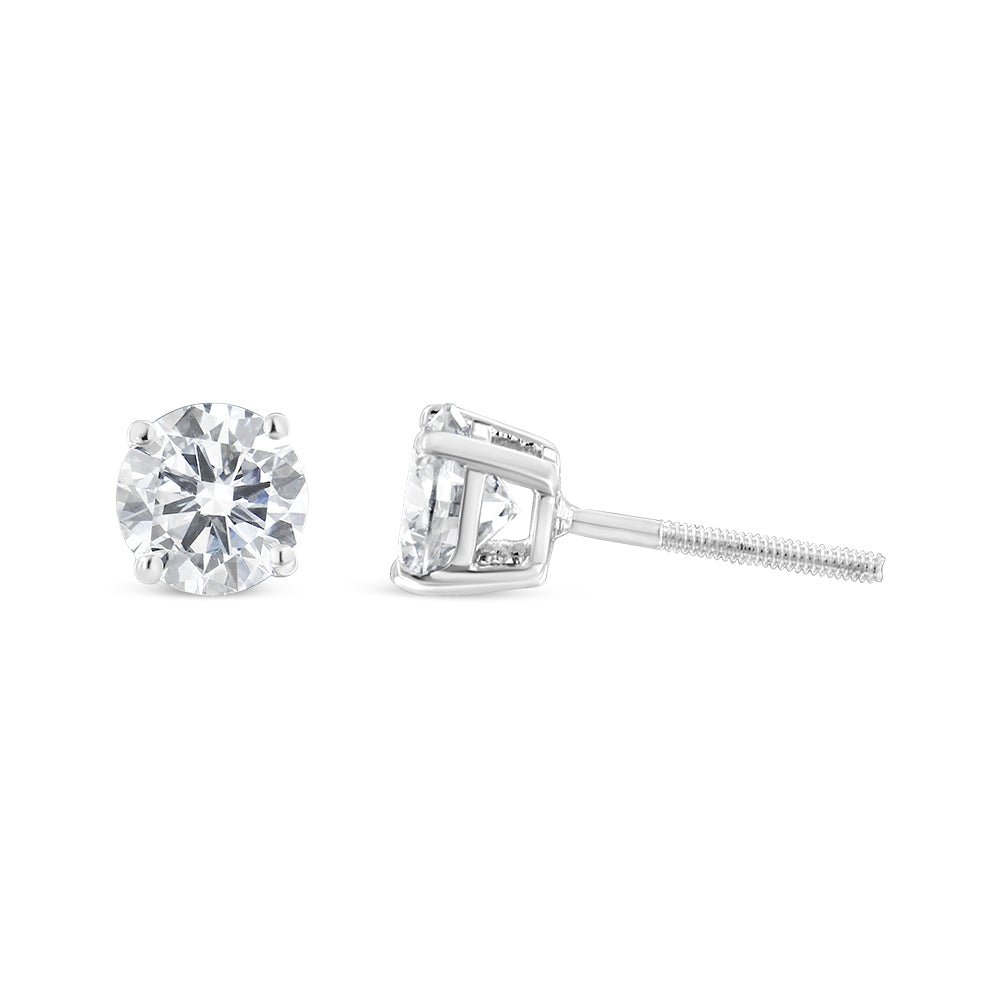 Pair of white metal stud earrings with round white gemstones in 4-prong settings, shown from front and side angles on a white background.