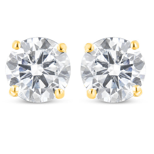 Front view of a pair of yellow metal stud earrings, each featuring a single round white gemstone in prong settings.