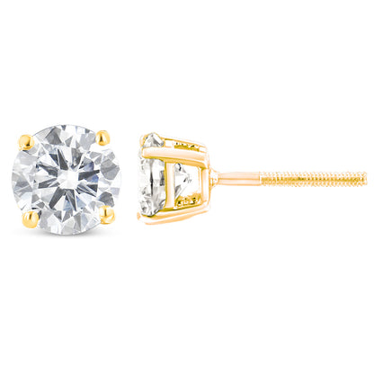 Pair of yellow metal stud earrings with round white gemstones in prong settings, shown from front and side angles.