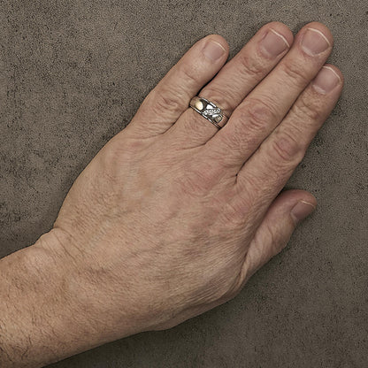 Close-up front angle of a white ring with three round white gemstones in a channel setting, shown worn on a model's finger.