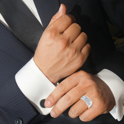 White metal ring with multiple princess-shaped white gemstones in an invisible setting, worn on a model's hand shown at a slight angle.