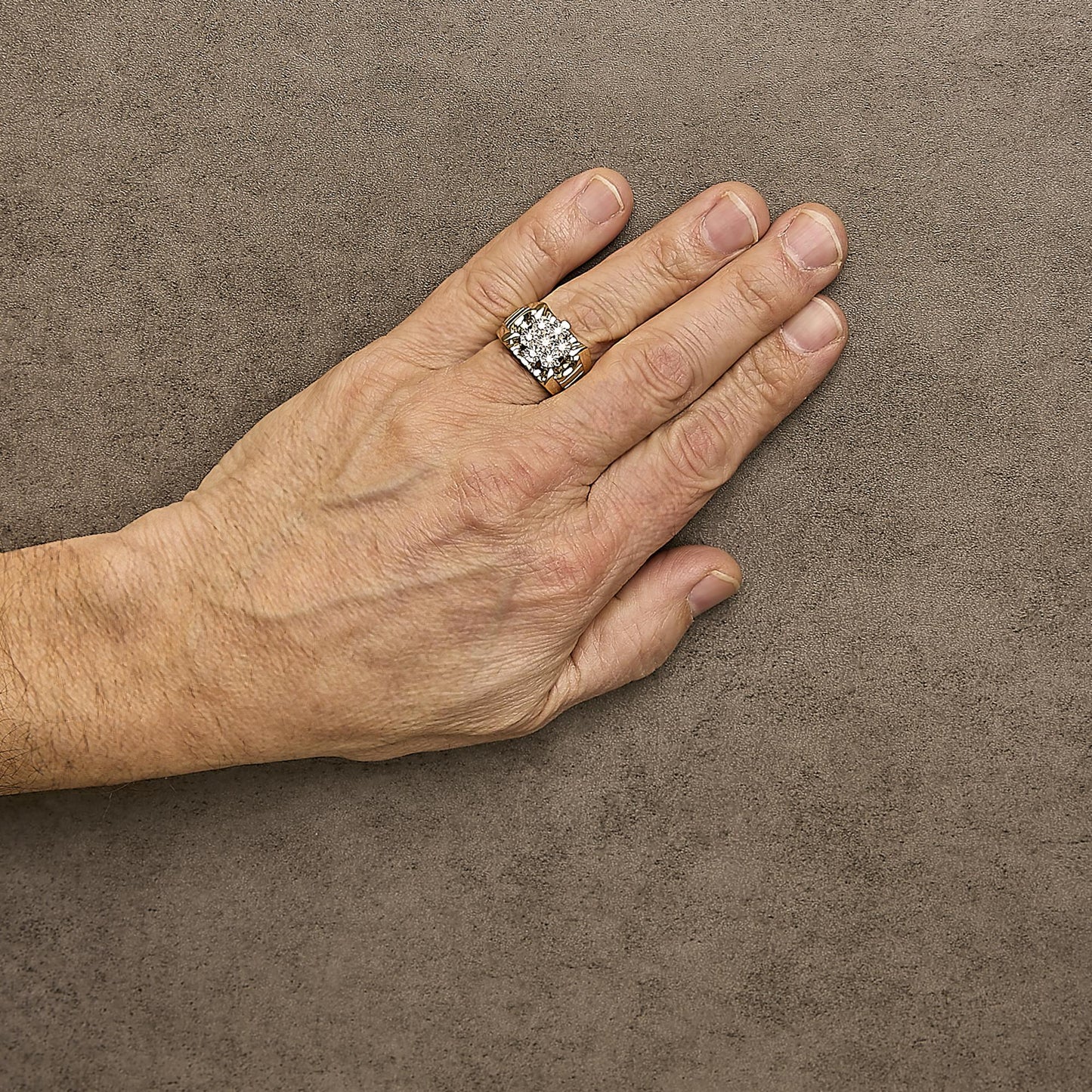 Yellow ring with seven round white gemstones in a miracle setting, worn on a model's finger, top-down angle.