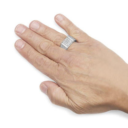 White metal ring with a square top featuring round white gemstones in miracle setting, shown worn on a model's hand from a top angle.