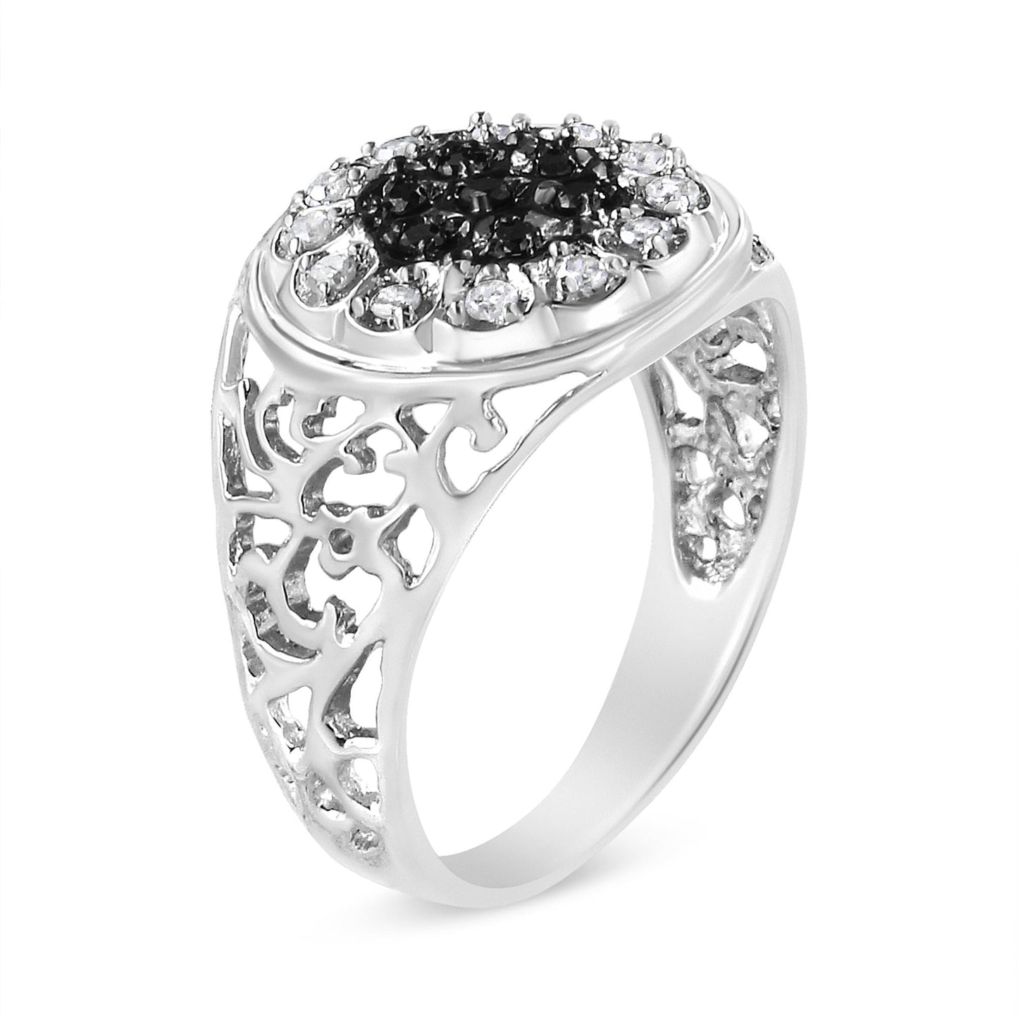 White metal ring with intricate filigree shank, featuring a cluster of round black and white gemstones in prong settings on the top, shown at a slight side angle.