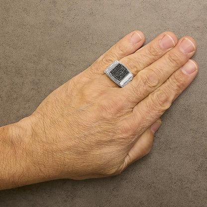 Ring with cluster of round black gemstones in prong setting on a white metal band, shown worn on a model's hand from a top angle.
