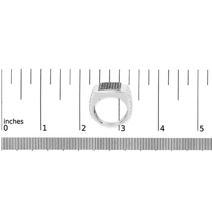 Image of a white ring with a rectangular top surface set with multiple round black gemstones in prong settings, shown on a measurement scale from above.