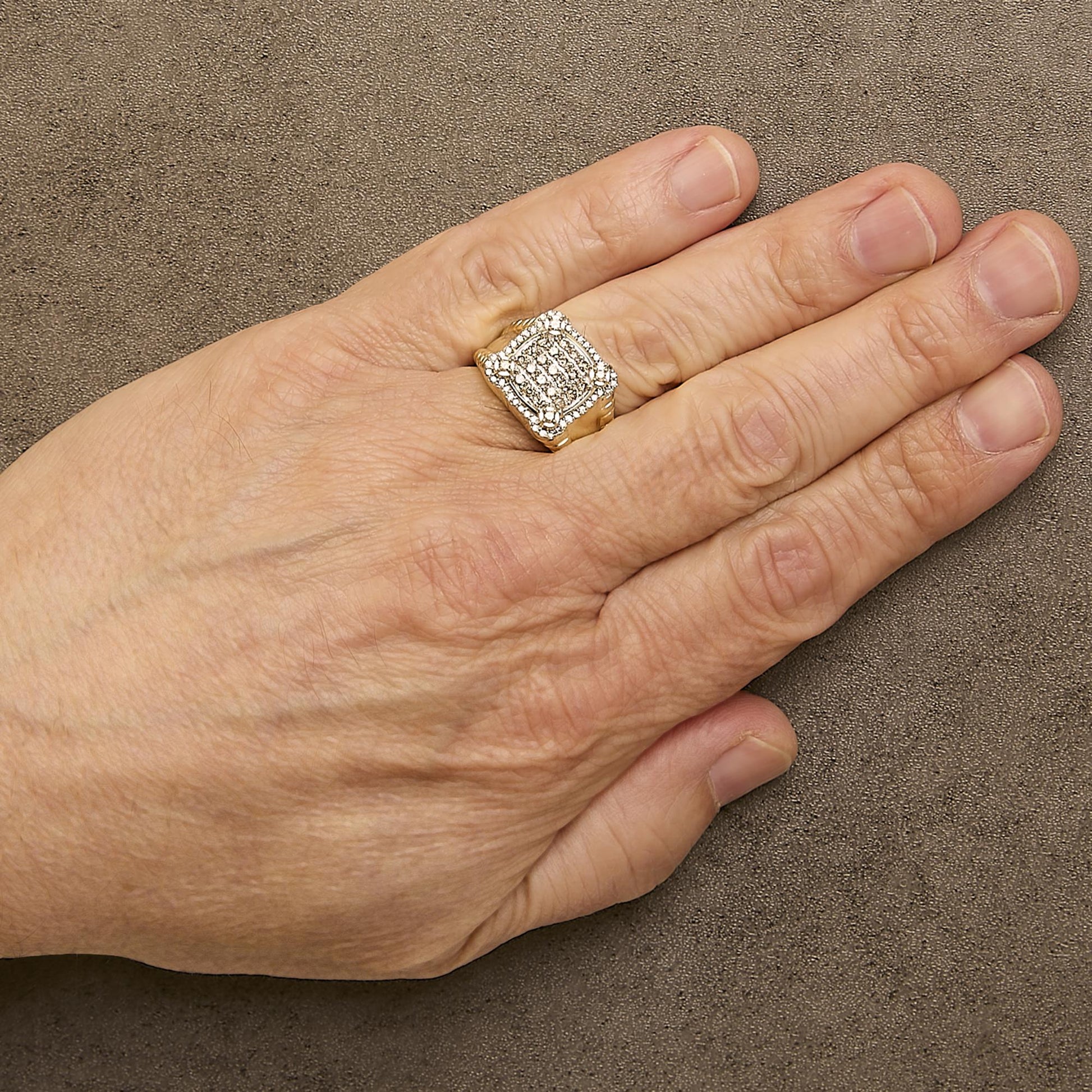 Close-up angled view of a yellow ring with multiple rows of small white gemstones in prong settings, shown worn on a model's finger.