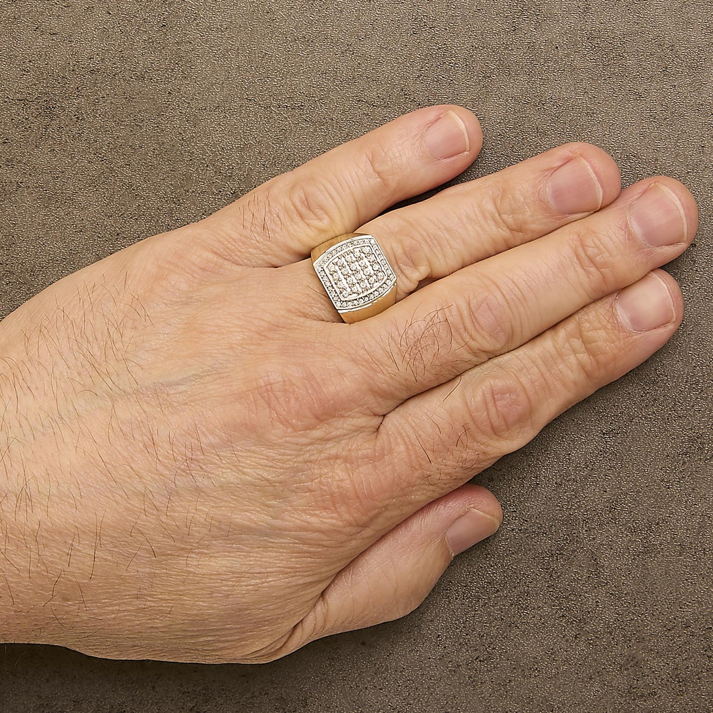 Yellow metal ring with a geometric shield-shaped top featuring two rows of round white gemstones in prong settings, shown worn on a model's hand from a top angle.