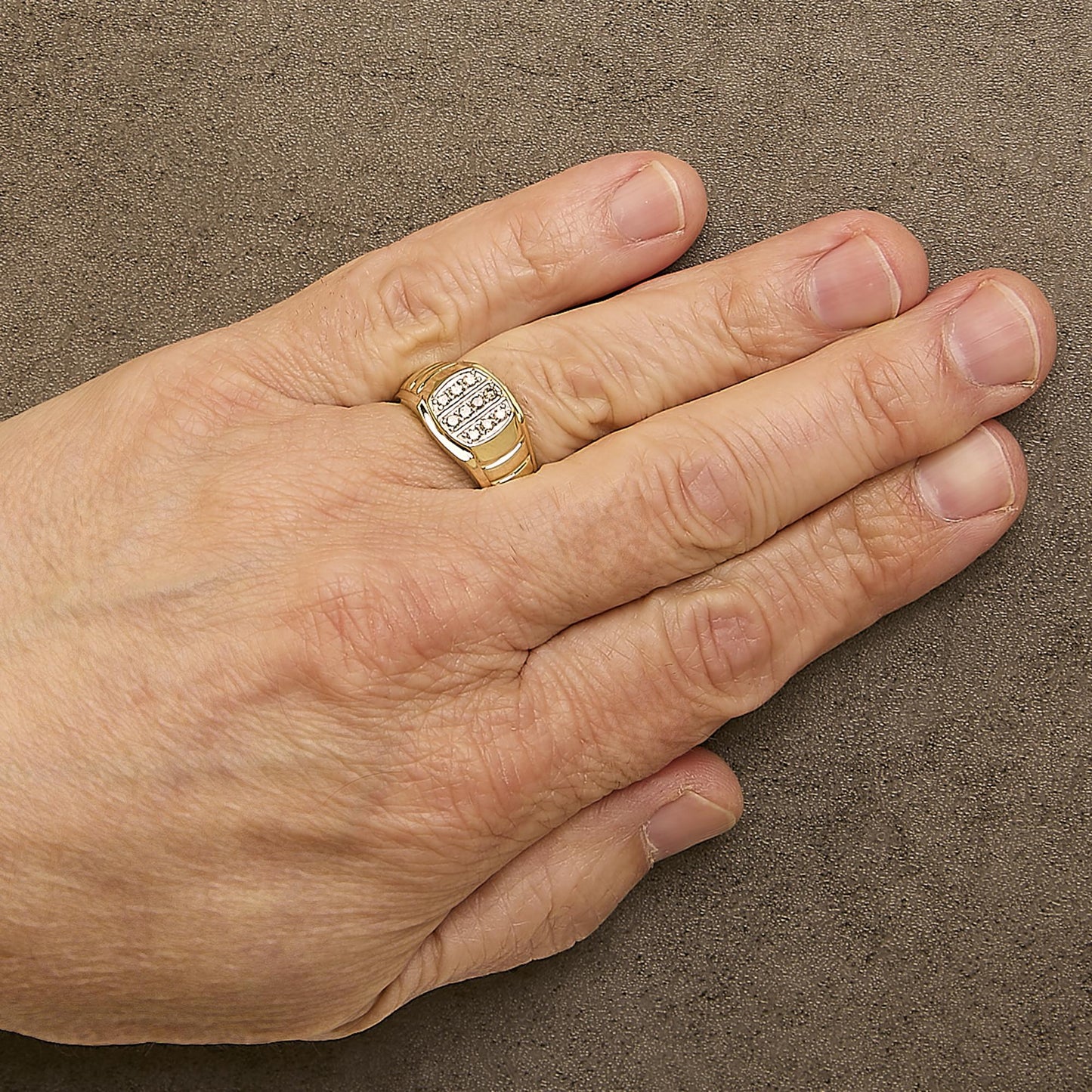 Close-up front angle of a yellow ring with rows of prong-set round white gemstones, shown worn on a model's finger.