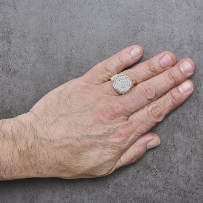 Close-up front angle of a hand model wearing a large yellow metal ring with a circular top encrusted with many round white gemstones in a 4-prong setting.