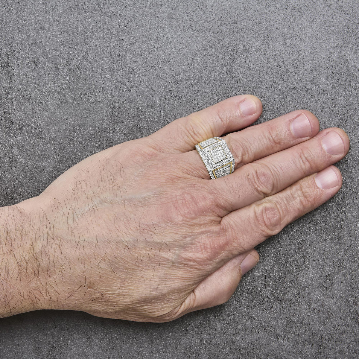 Yellow metal ring with multiple white gemstones in 4-prong settings arranged in square patterns, shown worn on a model's finger viewed from a top angle.
