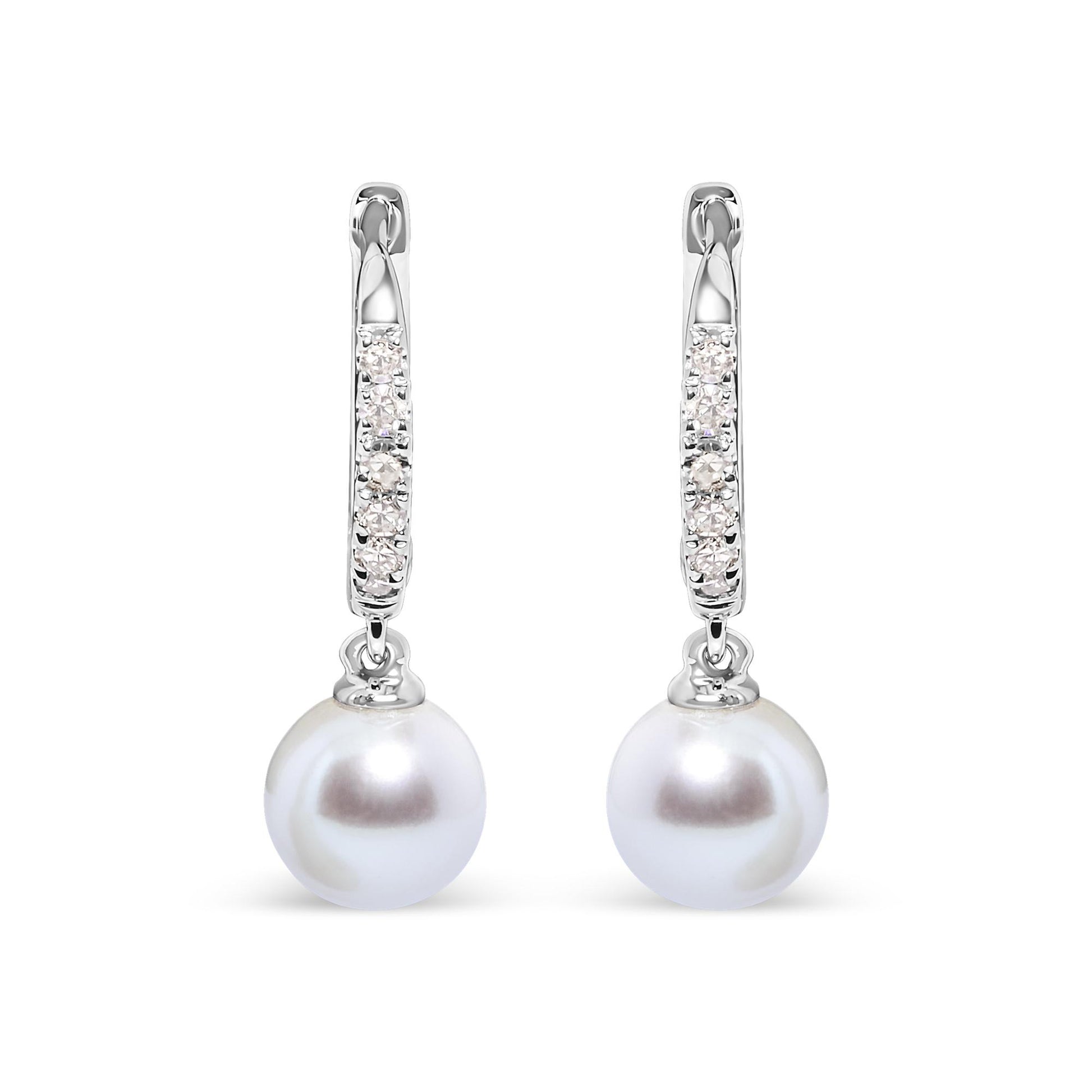 Front-facing view of white metal earrings with a hoop section featuring rows of small white gemstones in pave settings, each earring holding a single round white pearl drop.