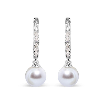 Front-facing view of white metal earrings with a hoop section featuring rows of small white gemstones in pave settings, each earring holding a single round white pearl drop.